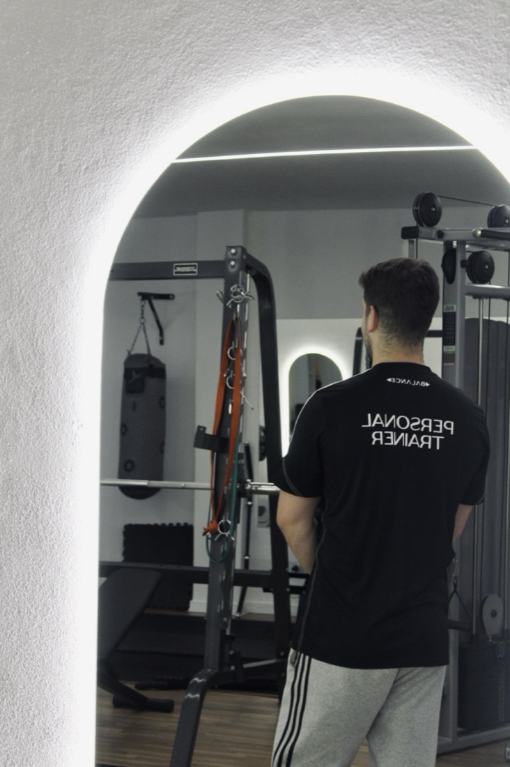 Personal trainer do Balance ao espelho na zona de treino
